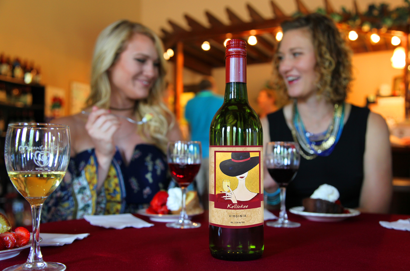 two women eating desert with a bottle of Kelliokee wine